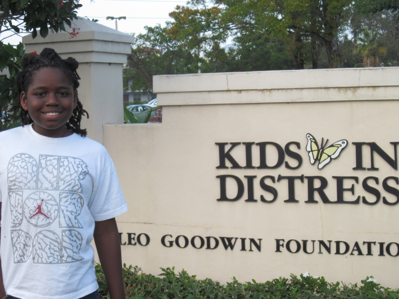 Ian Saunders (child) standing at Kids In Distress entrance sign